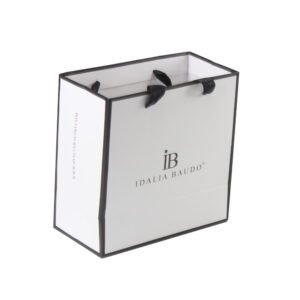 White art paper custom jewelry bags with logo, black border design, and black ribbon handles for luxury retail