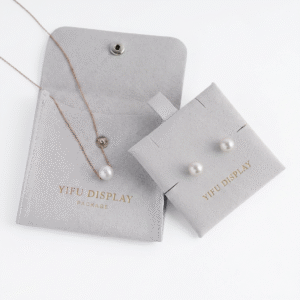 microfiber jewelry pouch with button closure and custom gold foil logo for necklace and earring packaging.