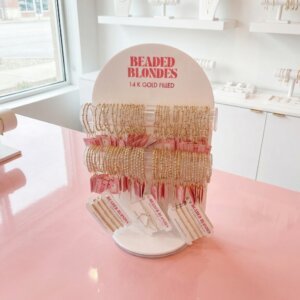Custom white acrylic jewelry display stand with transparent rods and curved top for bangle presentation featuring a sturdy base.